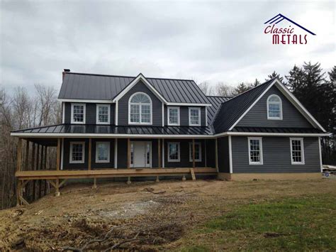 grey siding house with dark grey metal roof|black roof tan siding.